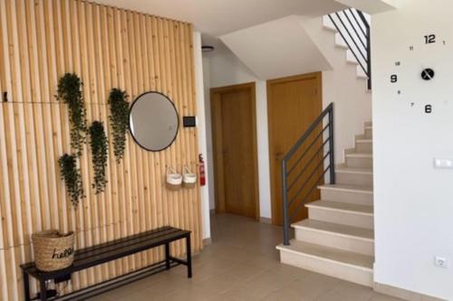 a hallway with a staircase and a mirror on a wall at Casa da alegria in Vau