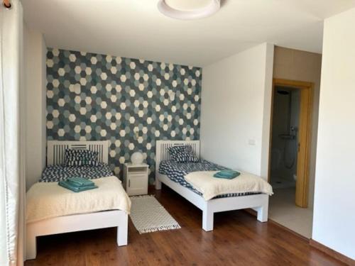 two beds in a room with a wall at Casa da alegria in Vau