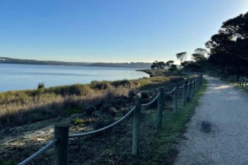 a path with a fence next to a body of water at Casa da alegria in Vau