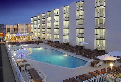 a hotel with a swimming pool in front of a building at ICONA Diamond Beach in Wildwood Crest