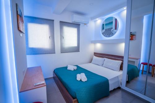 a small bedroom with a bed and a mirror at Tsolias Apartments in Protaras