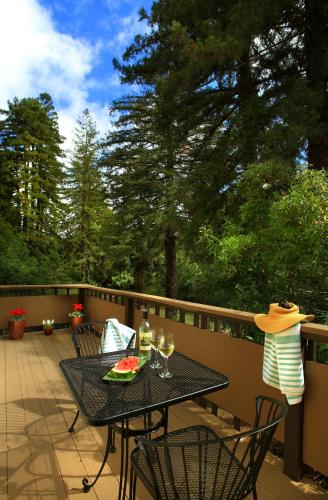 a table with a plate of food and wine glasses on a deck at West Sonoma Inn & Spa in Guerneville