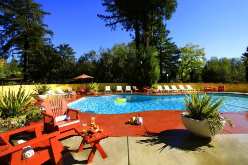uma piscina com duas cadeiras e uma mesa em West Sonoma Inn & Spa em Guerneville