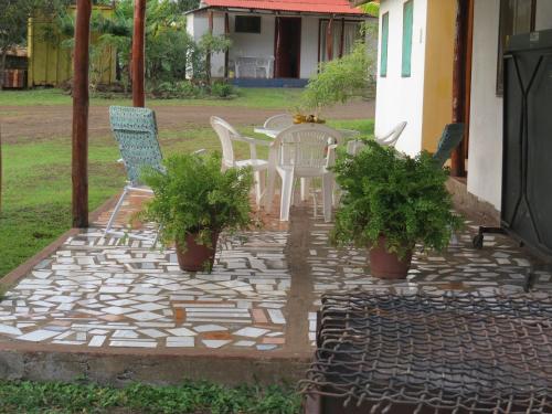 a patio with chairs and a table with plants at Cabañas Peretei in Hanga Roa