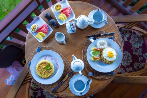 乌布内阳别墅 的一张木桌，上面摆放着食物盘子