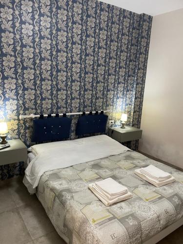- une chambre avec un lit et 2 tables avec des serviettes dans l'établissement Recente costruzione, centrale, tutti i comfort, à Pozzallo
