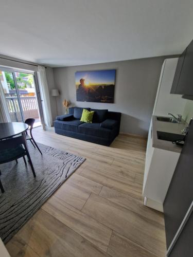 ein Wohnzimmer mit einem blauen Sofa und einem Tisch in der Unterkunft Anna & Paul Appartements in Söll