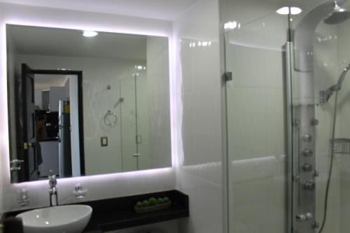 a bathroom with a shower and a sink and a mirror at Arriendos S.H. Nuevo Conquistador in Cartagena de Indias