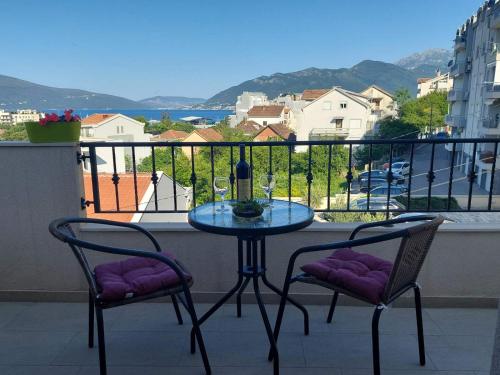 einen Tisch und zwei Stühle auf einem Balkon mit Aussicht in der Unterkunft LightHouse Apartments in Tivat