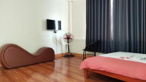 ein Schlafzimmer mit einem Bett und einem Ventilator in einem Zimmer in der Unterkunft NHÀ NGHỈ DU LỊCH MINH LONG - Quảng Trường in Cao Bằng