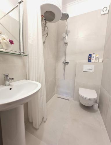 a white bathroom with a sink and a toilet at Friendly Apartment Golem in Golem