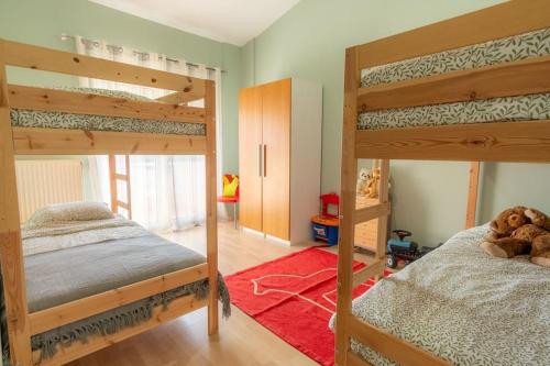 - une chambre avec 2 lits superposés et un tapis rouge dans l'établissement Maison Elisa, à Alexandroúpolis