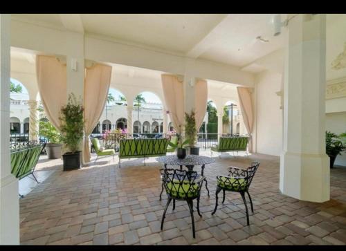 un patio con sillas y una mesa en un edificio en Tropical Elegant Palm Beach 2 Bedroom 2 Bathroom Suite Valet Parking Included, en Palm Beach