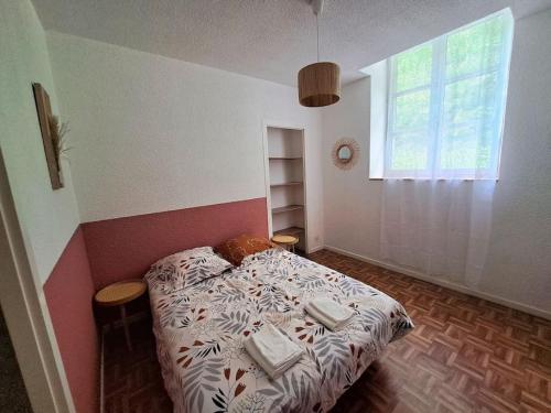 een slaapkamer met een bed met kussens erop bij Le Colibri - Appartement 4 à 6 couchages avec terrasse in Allemont