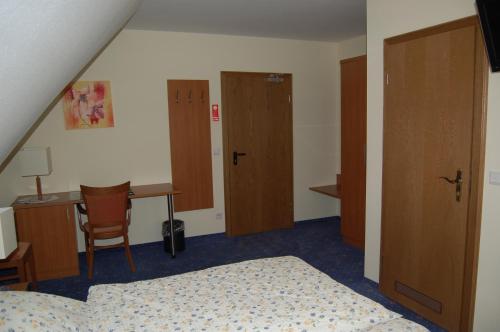 a bedroom with two beds and a desk and a table at Gasthof Waldesruh in Saerbeck