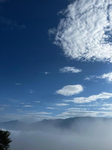 a blue sky with some clouds and a mountain at Himalayas in Gjirokastër