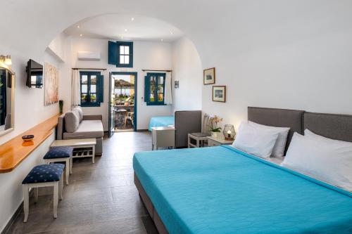 a bedroom with a bed and a living room at Kalimera Hotel in Akrotiri