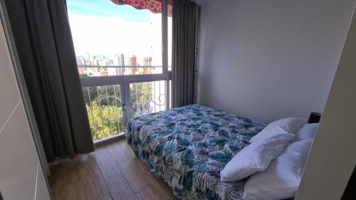 ein Schlafzimmer mit einem Bett und einem großen Fenster in der Unterkunft Apartamento Estudio Playmon Park 10-9 in Benidorm