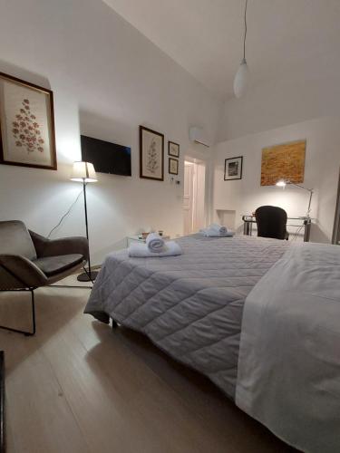 1 dormitorio con 1 cama grande y 1 silla en A casa di Frida, en Lecce