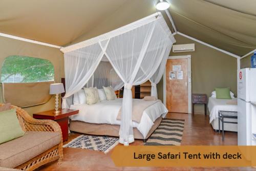 a large safari tent with a bed in a room at Crocodile Bridge Safari Lodge in Komatipoort