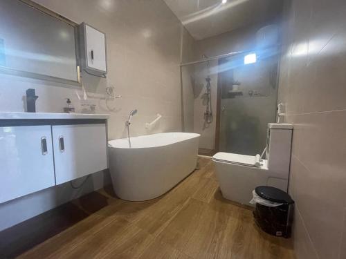 ein Bad mit einer Badewanne, einer Dusche und einem WC in der Unterkunft Delta in Dschidda