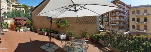 a white umbrella sitting on a patio with a table and bench at I love Rapallo La casa AlMar in Rapallo
