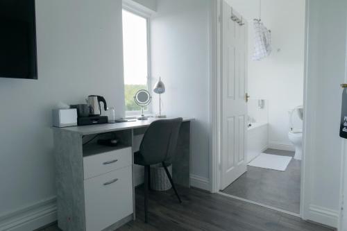 a white bathroom with a desk and a toilet at Isabella Rooms in Hockley