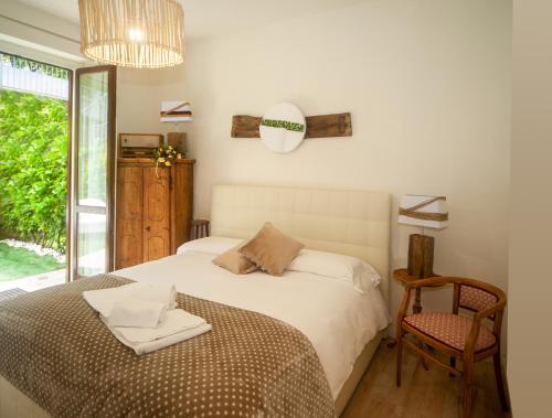 a bedroom with a bed and a chair and a window at Lake view 18 in Sale Marasino
