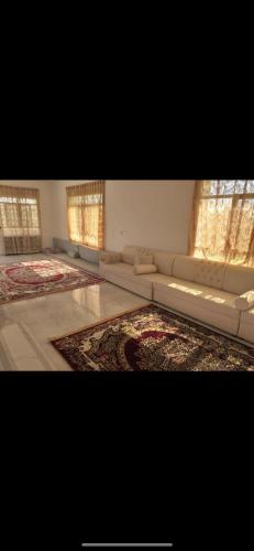 a large living room with couches and a rug at Sun shine chalet in Al Ḩadd