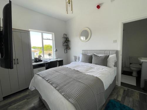 a white bedroom with a bed and a sink at Isabella Rooms in Hockley