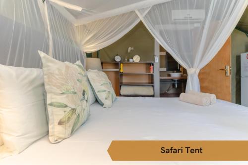 a bedroom with a white bed with pillows at Crocodile Bridge Safari Lodge in Komatipoort