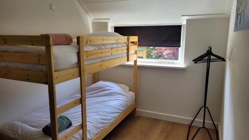 a bedroom with two bunk beds and a window at Betuwe Huisje in Meteren