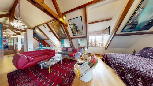 a living room with a red couch and a bed at Besharat Gallery & Museum in Barbizon