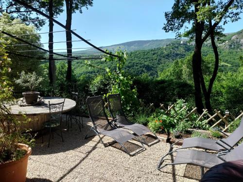 a patio with a table and chairs with a view at Gite du Prinas in Gréolières