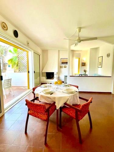 een eetkamer met een tafel en stoelen en een kamer met een patio bij Dimora dei pini in Leuca