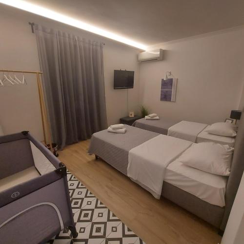 una camera d'albergo con due letti e una televisione di Eirini's Apartment a Análipsis