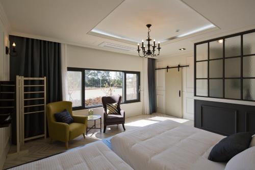 a bedroom with a large bed and a chandelier at Jimi Stay in Jeju
