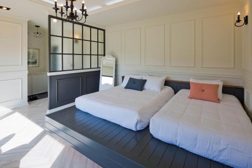 a bedroom with two beds and a chandelier at Jimi Stay in Jeju