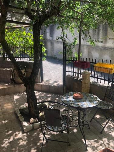 a table and chairs sitting next to a tree at IL PANORAMA in Altofonte