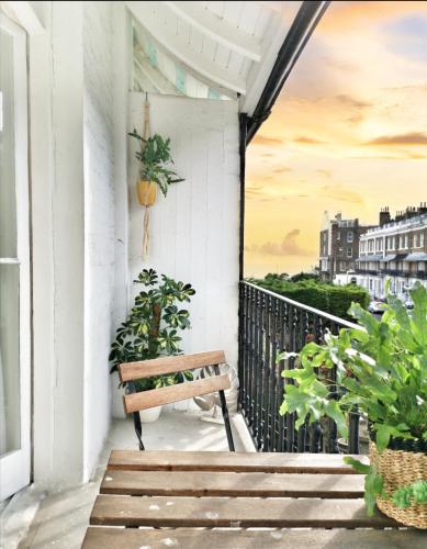 a bench on a balcony with a view of the city at Luminous Town house by the sea in Kent