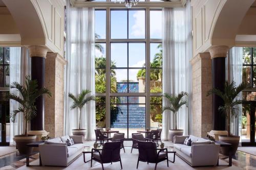 a lobby with white furniture and large windows at The Ritz-Carlton Coconut Grove, Miami in Miami