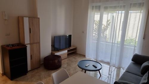 a living room with a couch and a tv at The Apartments in VALAMAR in Hamallë