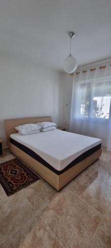 a bed in a white room with a large mattress at The Apartments in VALAMAR in Hamallë