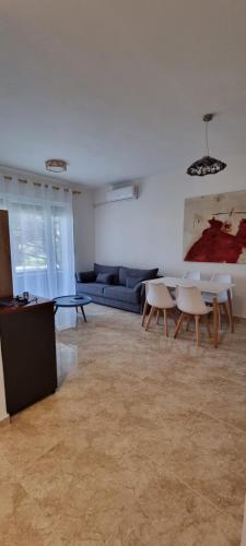 a living room with a couch and a table and chairs at The Apartments in VALAMAR in Hamallë