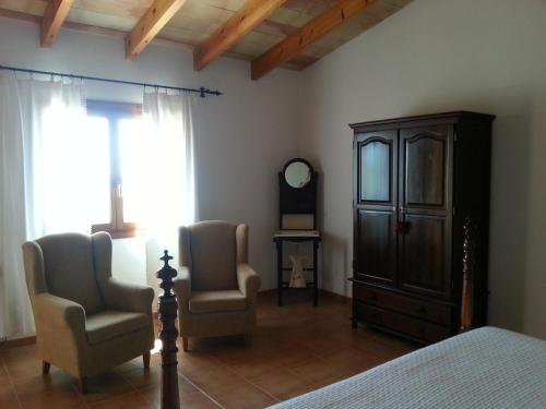 a bedroom with a bed and two chairs and a dresser at Agroturismo Finca Son Sala in Campos