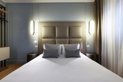 a bedroom with a large white bed with two pillows at PRESTIGE BOUTIQUE APARTHOTEL - Piazza Duomo View in Milan