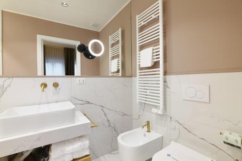 a white bathroom with a sink and a mirror at PRESTIGE BOUTIQUE APARTHOTEL - Piazza Duomo View in Milan