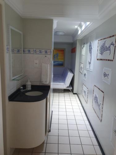 Un baño con lavabo y una cama en una habitación. en Flat na Boa Viagem Recife A, en Recife