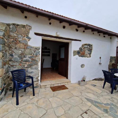 a patio with two chairs and a building at THE ROCK HOUSE - Beautiful countryside with mandarins oranges and olive trees,. Near Limassol at Eptagonia village. in Ephtagonia