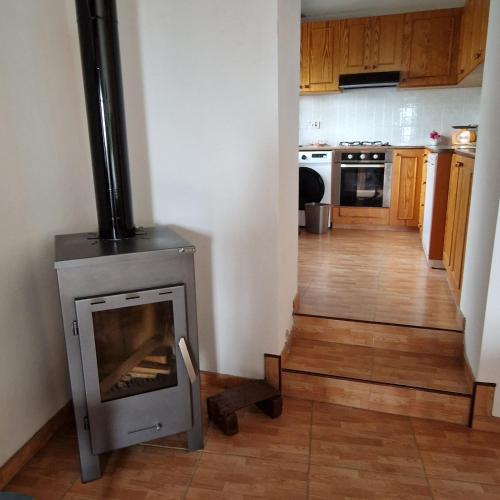 a kitchen with a wood stove in a room at THE ROCK HOUSE - Beautiful countryside with mandarins oranges and olive trees,. Near Limassol at Eptagonia village. in Ephtagonia